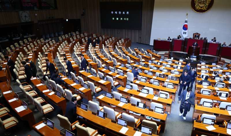 [서울=뉴시스] 김명년 기자 = 12일 오후 서울 여의도 국회에서 열린 본회의에서 이헌승 국민의힘 의원이 은행법 일부개정법률안에 대한 무제한토론(필리버스터)을 시작하자 더불어민주당 의원들이 회의장을 나서고 있다. 2025.12.12. photo@newsis.com