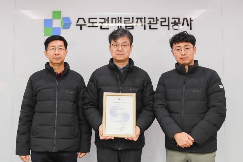 [인천=뉴시스] 류돈식 자원순환기술연구소장(가운데)이 '음식물류폐기물 처리시설 검사기관 지정서'를 들고 검사 업무 담당 직원들과 기념 촬영하고 있다. (사진=수도권매립지관리공사 제공) 2025.12.12. photo@newsis.com