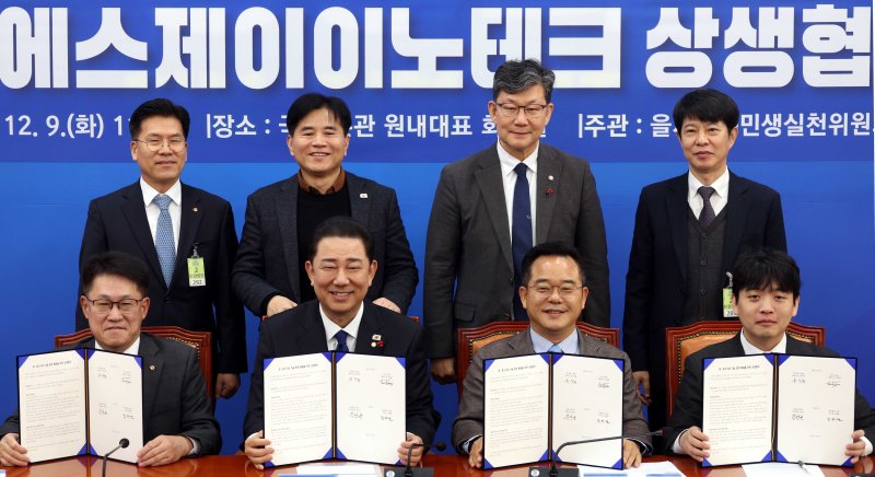 [서울=뉴시스] 조성봉 기자 = 김병기 더불어민주당 원내대표가 9일 오전 서울 여의도 국회에서 열린 대중소기업 기술 분쟁 해결을 위한 상생협약식에서 참석자들과 기념촬영을 하고 있다. 앞줄 왼쪽부터 류두형 한화 글로벌부문 대표이사, 김 원내대표, 민병덕 을지로위원장, 정성호 에스제이 이노테크 대표이사. 2025.12.09. suncho21@newsis.com