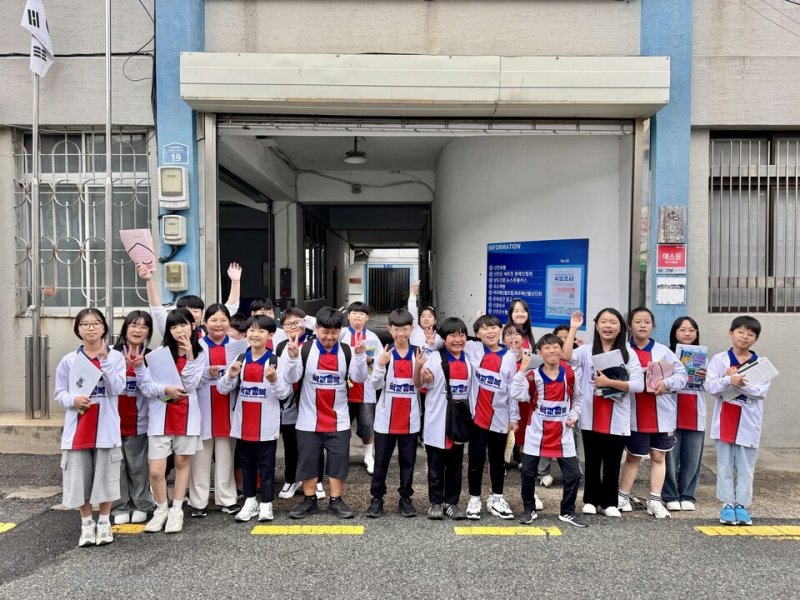 학생들이 영화 '학교정복' 홍보 티셔츠를 입고 현장체험 인증 사진에 포즈를 취하고 있다.(전남도교육청 제공, 재판매 및 DB 금지)/뉴스1