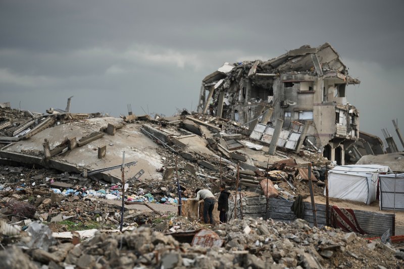 [가자시티=AP/뉴시스] 지난 11일(현지 시간) 가자지구 가자시티에 겨울 폭풍이 지나간 후 팔레스타인 난민들이 폐허 속을 걷고 있다. 2025.12.14.