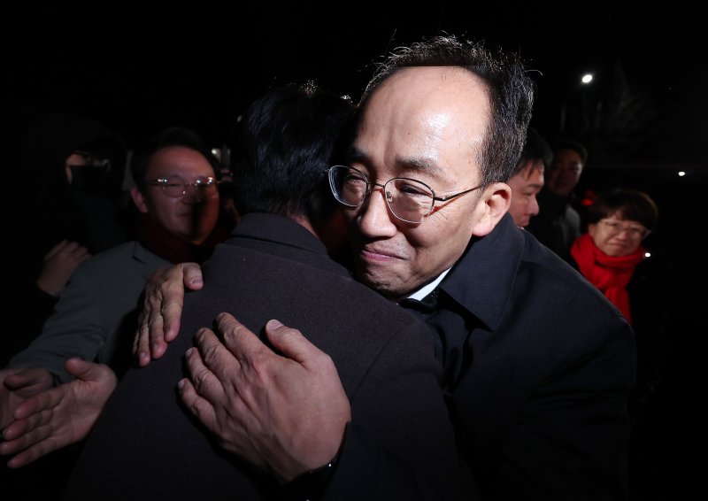 12·3 비상계엄 해제 요구안 표결 방해 의혹을 받는 추경호 국민의힘 의원이 지난 3일 새벽 구속 영장이 기각된 후 경기도 의왕시 서울구치소를 나서며 동료 의원들과 포옹하고 있다./뉴스1 ⓒ News1 김성진 기자