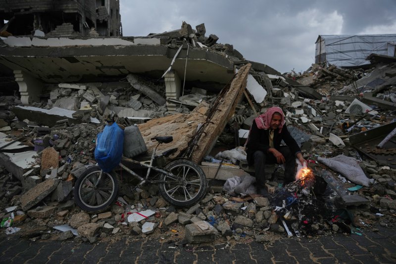 [가자시티=AP/뉴시스] 팔레스타인 가자지구 가자시티에서 12일 난민이 이스라엘 공습과 지상작전으로 파괴된 잔해에 앉아 불을 쬐고 있다. 2025.12.13.