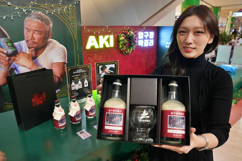 모델이 서울 잠실 롯데월드몰에서 진행 중인 '압구정 막걸리 X 아키사케 콜라보 팝업스토어'에서 상품을 홍보하고 있다. 롯데백화점 제공