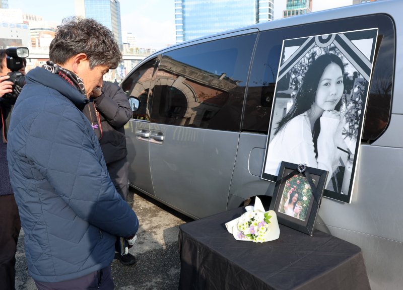 [서울=뉴시스] 이영환 기자 = 14일 오후 서울 용산구 서울역 앞에서 열린 2025 세계 이주노동자의 날 기념 전국이주노동자대회에서 참석자가 고 뚜안씨를 추모하고 있다. 2025.12.14. 20hwan@newsis.com