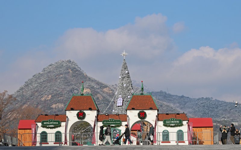 성탄절을 열흘 여 앞둔 14일 오후 서울 종로구 광화문광장을 찾은 시민들이 눈 덮인 북악산을 배경으로 겨울동화 속 산타마을 콘셉트로 꾸며진 크리스마스 광화문 마켓을 둘러보고 있다. 2025.12.14/뉴스1 ⓒ News1 오대일 기자