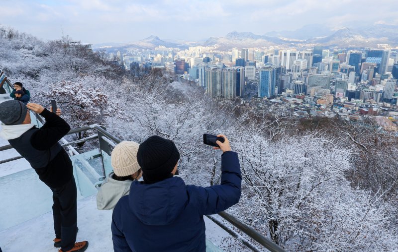 지난 밤 내린 눈이 쌓인 14일 서울 용산구 남산공원을 찾은 시민들이 겨울풍경을 만끽하고 있다. 2025.12.14/뉴스1 ⓒ News1 이호윤 기자