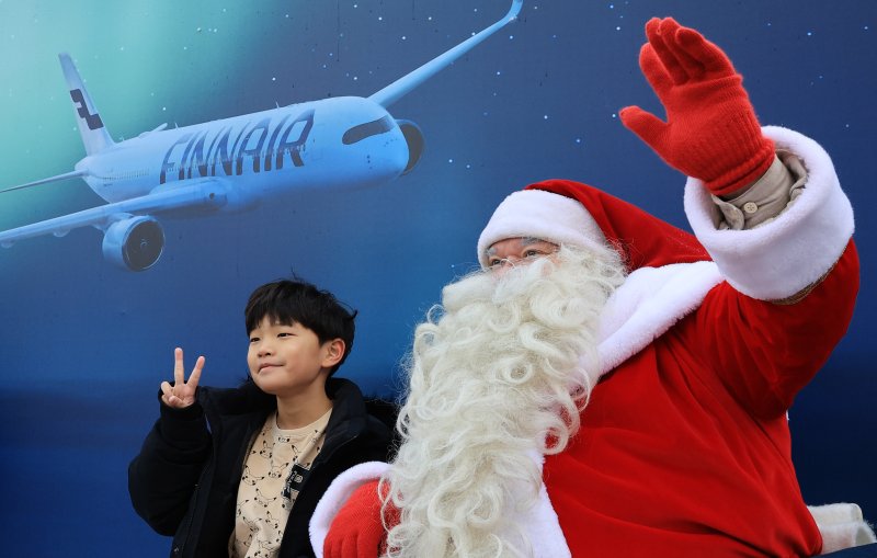 한국을 찾은 핀란드 공인 산타클로스가 14일 서울 중구 남산타워 앞에서 아이와 기념촬영을 하고 있다. 2025.12.14/뉴스1 ⓒ News1 이호윤 기자