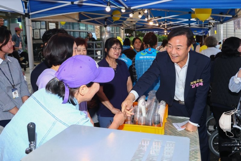 김성제 경기 의왕시장이 16일 부곡동 주민복지관에서 장애인 자립을 지원하고, 지역사회 연대와 포용 가치를 실현하기 위해 열린 '2025 더(The)함께 바자회'를 찾아 참석자들과 인사를 나누고 있다. 김 시장은 "앞으로도 어려운 이웃들이 희망을 되찾을 수 있도록 더욱 관심을 기울이겠다＂고 말했다. (의왕시 제공. 재판매 및 DB 금지) 2025.10.16/뉴스1 ⓒ News1 김기현 기자