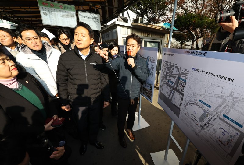[서울=뉴시스] 최진석 기자 = 오세훈 서울시장이 15일 서울 광진구 동서울터미널 부지 현장을 찾아 공공개발담당관으로부터 개발계획 보고를 받고 있다. 2025.12.15. myjs@newsis.com