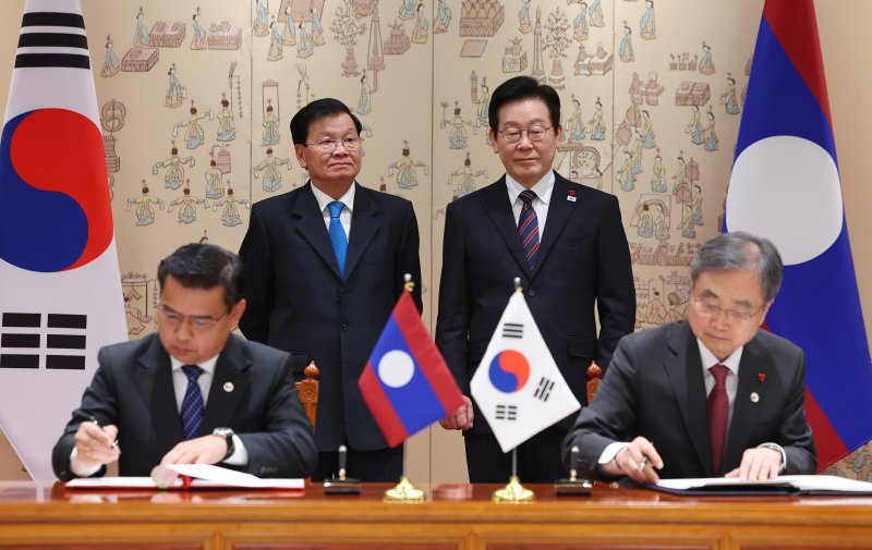 [서울=뉴시스] 최동준 기자 = 조현 외교부 장관과 싸이싸나 콧푸톤 라오스 검찰총장이 15일 용산 대통령실에서 이재명 대통령과 통룬 시술릿 라오스 국가주석이 임석한 가운데 형사사법공조 조약 체결식을 하고 있다. (대통령실통신사진기자단) 2025.12.15. photocdj@newsis.com