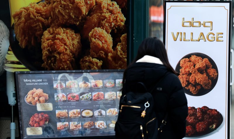 치킨을 판매할 때 조리 전 닭고기 무게를 소비자에게 고지해야 하는 '치킨 중량표시제'가 본격적으로 시행되는 15일 서울 시내의 한 BBQ매장 앞으로 시민이 지나가고 있다. '치킨 중량표시제'는 치킨의 가격은 그대로 두고 무게를 줄이는 꼼수 인상하는 '슈링크플레이션'을 방지하기 위해 공정거래위원회, 식품의약품안전처 등 관계 부처가 합동으로 마련했으며 bhc, BBQ치킨, 교촌치킨, 처갓집양념치킨 등 상위 10개 브랜드가 매장 및 배달 주문 메뉴판에 닭고기의 조리 전 총중량을 명시해야 한다. 2025.12.15/뉴스1 ⓒ News1 이