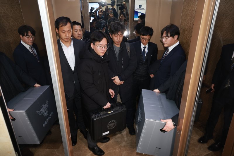 [서울=뉴시스] 고승민 기자 = 경찰이 통일교 관련 전방위적으로 압수수색에 나선 15일 서울 여의도 국회 의원회관 전재수 더불어민주당 의원실 압수수색을 마친 경찰 국가수사본부 관계자가 압수물품을 들고 건물을 나서고 있다. 2025.12.15. kkssmm99@newsis.com