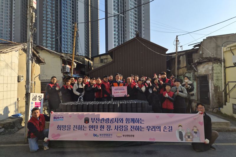 지난 16일 오후 부산 동구 매축지마을 일대에서 진행된 ‘2025 부산관광공사 연탄나눔 봉사’에 참여한 공사 임직원들이 부산연탄은행에 성금 400만원을 기부하며 기념촬영하고 있다. 부산관광공사 제공