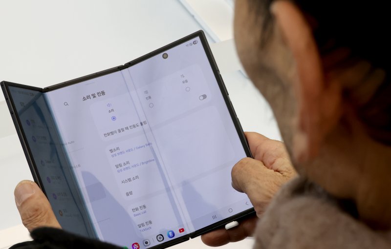 갤럭시 Z 트라이폴드가 출시된 12일 오전 서울 서초구 삼성 강남을 찾은 어르신이 제품을 살펴보고 있다. 2025.12.12/뉴스1 ⓒ News1 장수영 기자