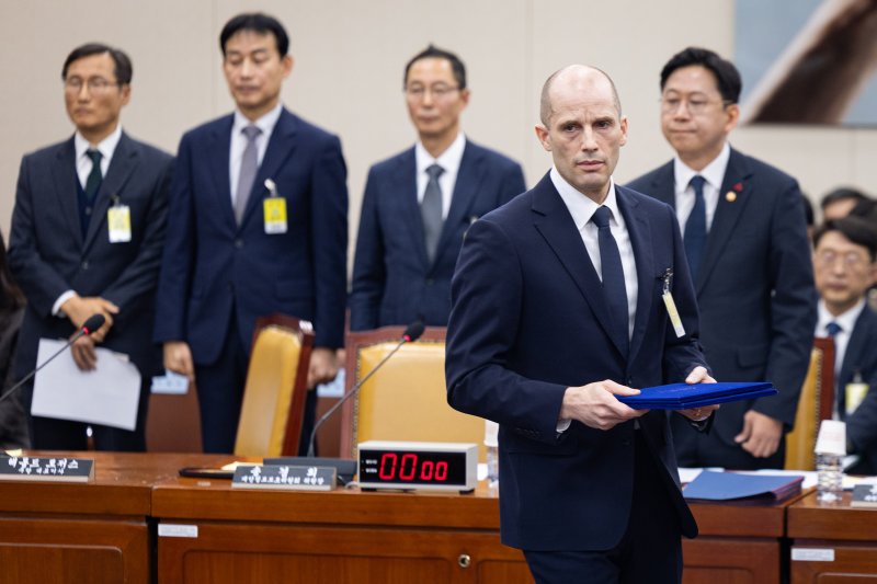 해롤드 로저스 쿠팡 임시 대표가 17일 서울 여의도 국회 과학기술정보방송통신위원회에서 열린 쿠팡 개인정보 유출 사고 관련 청문회에서 증인 선서를 마친 후 최민희 과방위원장에게 선서문을 전달하기 위해 이동하고 있다. 2025.12.17/뉴스1 ⓒ News1 유승관 기자