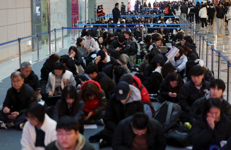 [서울=뉴시스] 홍효식 기자 = 18일 서울 강남구 코엑스에서 열린 2026학년도 정시 대학입학정보박람회를 찾은 학부모와 입시생들이 입장하기 위해 앉아 기다리고 있다. 2025.12.18. yesphoto@newsis.com