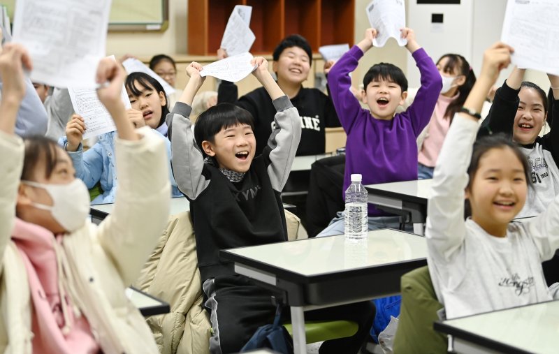 [수원=뉴시스] 김종택 기자 = 겨울방학식이 열린 16일 경기 수원시 영통구 잠원초등학교에서 4학년8반 학생들이 방학안내문을 들어보이고 있다. 2025.12.16. jtk@newsis.com