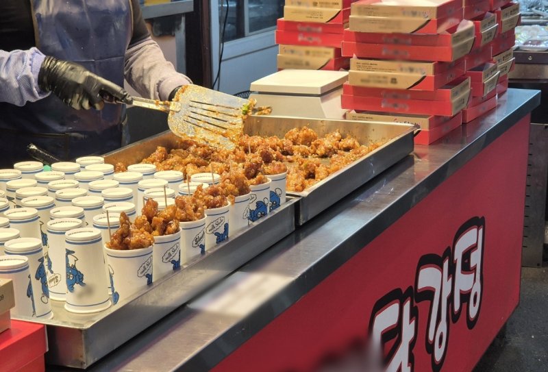 토요일인 20일 강원 강릉지역 대표 전통시장인 중앙·성남시장 내 닭강정 판매 업소 종사자가 손님들에게 내어 줄 닭강정을 볶고 있다.2025.12.20/뉴스1 윤왕근 기자