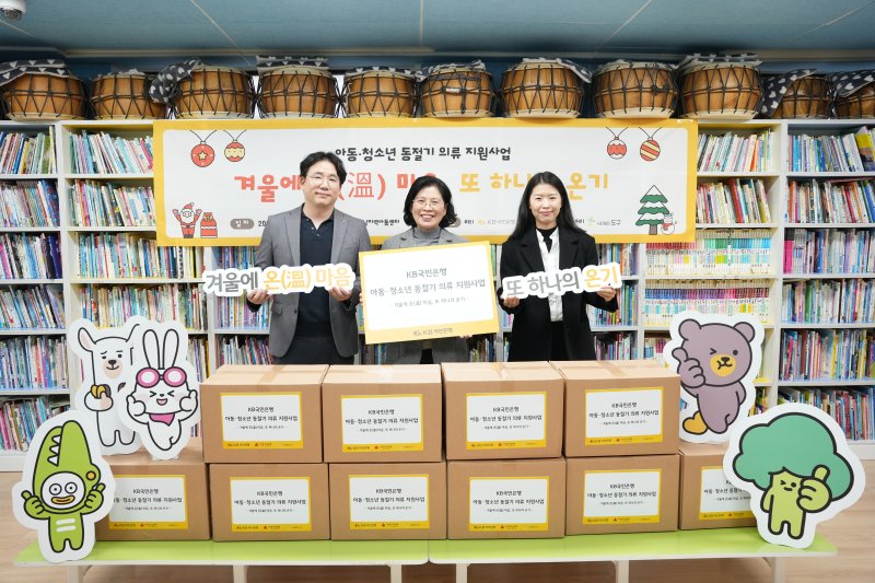 김동규 KB국민은행 포용금융부 차장(왼쪽부터), 김금자 새날지역아동센터장, 정현아 사단법인 도구 대표가 지난 23일 서울 광진구 새날지역아동센터에서 열린 방한의류 전달식에서 기념촬영을 하고 있다.KB국민은행 제공