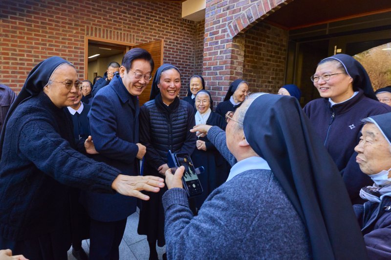 [서울=뉴시스] 최동준 기자 = 이재명 대통령이 25일 인천 계양구 노틀담 수녀원을 방문해 수녀들과 성탄 인사를 나누며 기념촬영을 하고 있다. (사진=대통령실 제공) 2025.12.25. photo@newsis.com *재판매 및 DB 금지