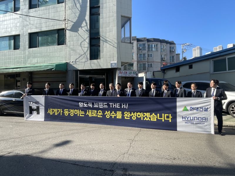 30일 성수전략정비구역 제1지구 주택재개발정비사업조합 사무실 앞에 현대건설 관계자들이 플래카드를 들고 서 있다. 사진=권준호 기자