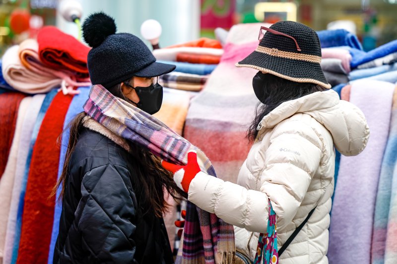[서울=뉴시스] 정병혁 기자 = 서울 중구 명동을 찾은 여행객이 목도리를 고르고 있다. 2025.12.27. jhope@newsis.com /사진=뉴시스