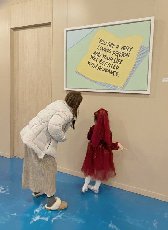 모모킴 작가의 ‘An Invitation to Everyday Life’ 전시회 포스터를 12월 23일 전시 오프닝 프리뷰 리셉션에 참여한 e편한세상 송도 입주민이 ‘OUUM’ 적용 공간에서 전시 작품을 감상하고 있다.