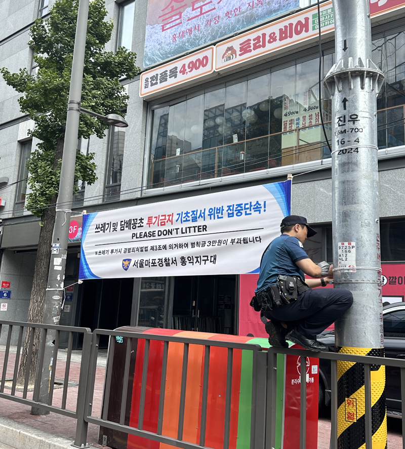 장주웅 경위가 '기초질서 위반 집중단속' 현수막을 설치하고 있다. 본인 제공