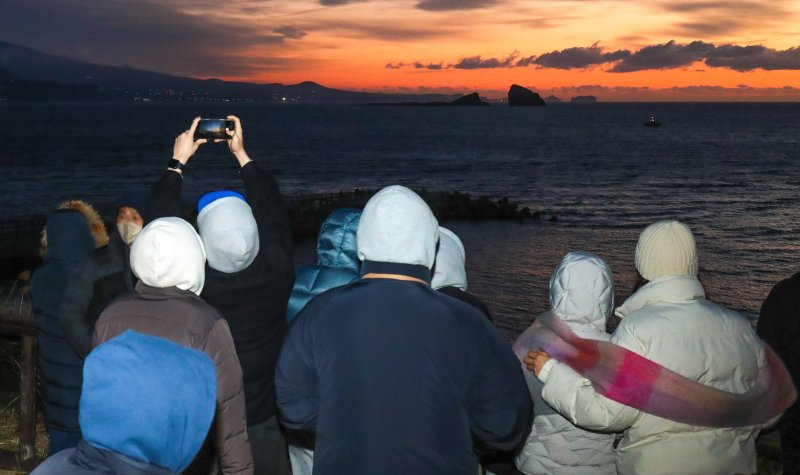 [서귀포=뉴시스] 우장호 기자 = 병오년(丙午年) 새해 첫날인 1일 오전 제주 서귀포시 대정읍 송악산 둘레길을 찾은 해맞이객들이 구름 뒤로 떠오르는 일출을 맞이하고 있다. 2026.01.01. woo1223@newsis.com