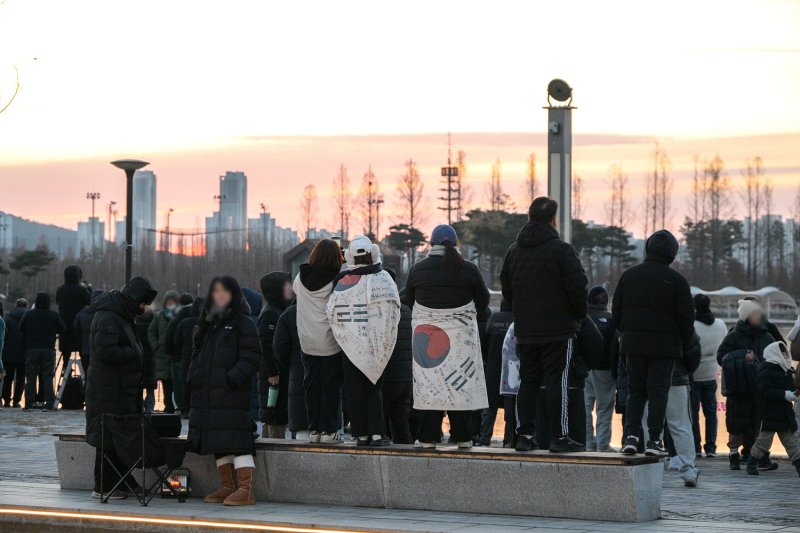 [세종=뉴시스] 1일, 세종호수공원에서 태극기를 허리에 두룬 시민들이 일출을 기다리고 있다.(사진=세종시 제공). 2026.01.01. photo@newsis.com. *재판매 및 DB 금지