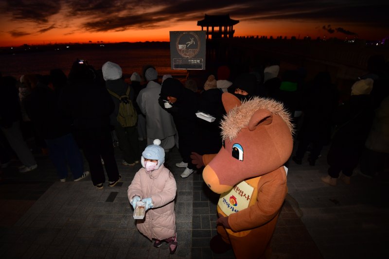 2026년 병오년 새해 첫 날인 1일 경북 포항시 영일대해수욕장 해상누각 앞에서 적토마 인형 옷을 입은 포항불교사암연합회원이 어린이들에게 가래떡을 나눠주고 있다. 2026.1.1/뉴스1 ⓒ News1 최창호 기자