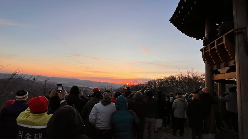 [청주=뉴시스] 2026년 첫날인 1일 충북 청주시 봉무산 정상에서 시민들이 새해 첫 일출을 보고 있다. (사진= 청주시 제공) 2026.01.01. photo@newsis.com *재판매 및 DB 금지