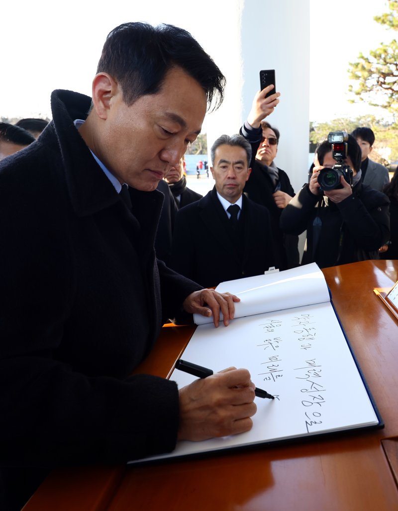 [서울=뉴시스] 박주성 기자 = 오세훈 서울시장이 2026년 새해 첫날인 1일 서울 동작구 국립서울현충원 참배를 마친 후 방명록을 작성하고 있다. 2026.01.01. park7691@newsis.com
