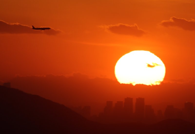 [서울=뉴시스] 배훈식 기자 = 2025년 을사년(乙巳年)의 마지막 날인 31일 오후 서울 용산구 서울N타워에서 바라본 마지막 해넘이를 뒤로하고 비행기가 날고 있다. 2025.12.31. dahora83@newsis.com