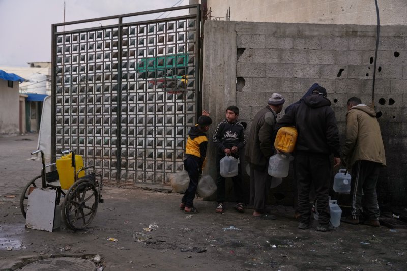 [데이르 알발라=AP/뉴시스] 지난달 23일(현지 시간) 가자지구 중부 데이르 알발라 난민 천막촌에서 팔레스타인 피란민들이 물을 받고 있다. 2026.01.03.