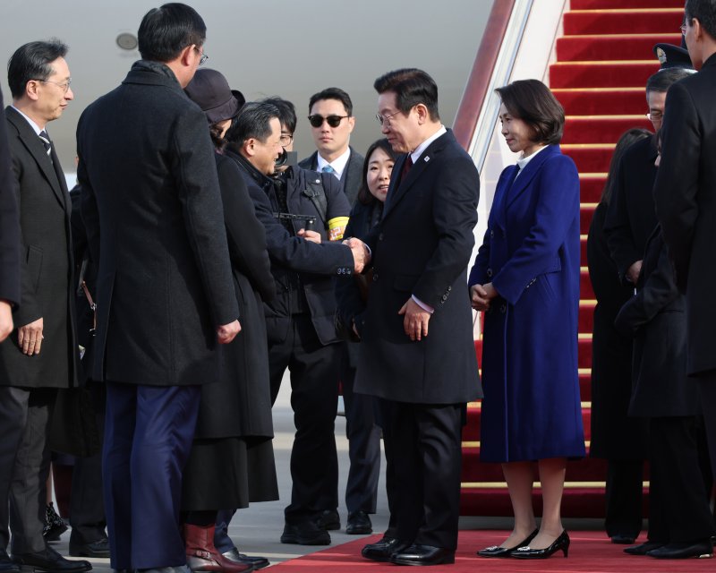 [베이징=뉴시스] 최동준 기자 = 중국을 국빈 방문한 이재명 대통령과 김혜경 여사가 4일(현지 시간) 베이징 서우두 국제공항에 도착해 환영 인사들과 인사하고 있다. 2026.01.04. photocdj@newsis.com