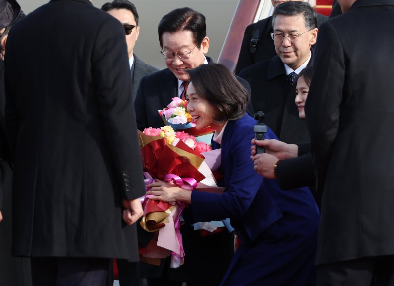 [베이징=뉴시스] 최동준 기자 = 이재명 대통령과함께 중국을 국빈 방문한 김혜경 여사가 4일(현지 시간) 베이징 서우두 국제공항에 도착해 꽃다발을 받고 있다. 2026.01.04. photocdj@newsis.com