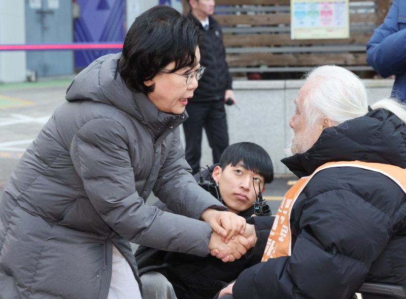 [서울=뉴시스] 김진아 기자 = 이혜훈 기획예산처 장관 후보자가 5일 오전 서울 중구 예금보험공사에 마련된 인사청문회 준비 사무실로 출근하며 박경석 전국장애인차별철폐연대(전장연) 상임공동대표와 대화를 하고 있다. 2025.01.05. bluesoda@newsis.com