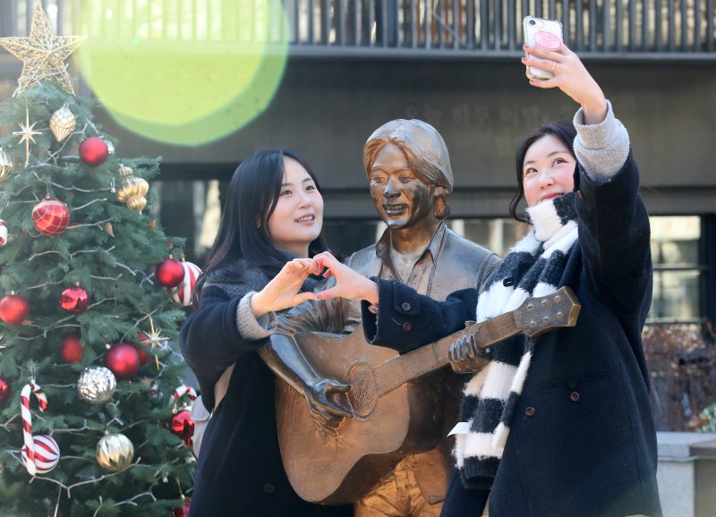 '영원한 가객' 고(故) 김광석(1964∼1996) 30주기인 6일 오후 대구 중구 방천시장 김광석길을 찾은 시민들이 김광석 동상 옆에서 기념촬영을 하고 있다. 2026.1.6/뉴스1 ⓒ News1 공정식 기자