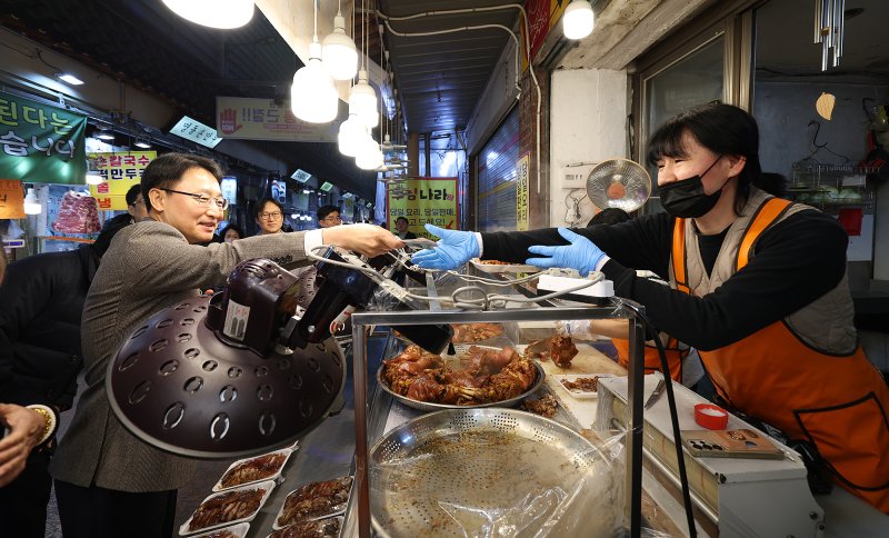 임광현 국세청장이 6일 수원 팔달구 소재 못골시장을 방문해 소상공인들과 대화를 나누고 음식을 구매하고 있다.(사진 : 국세청 제공) 2026.1.7. *재판매 및 DB 금지