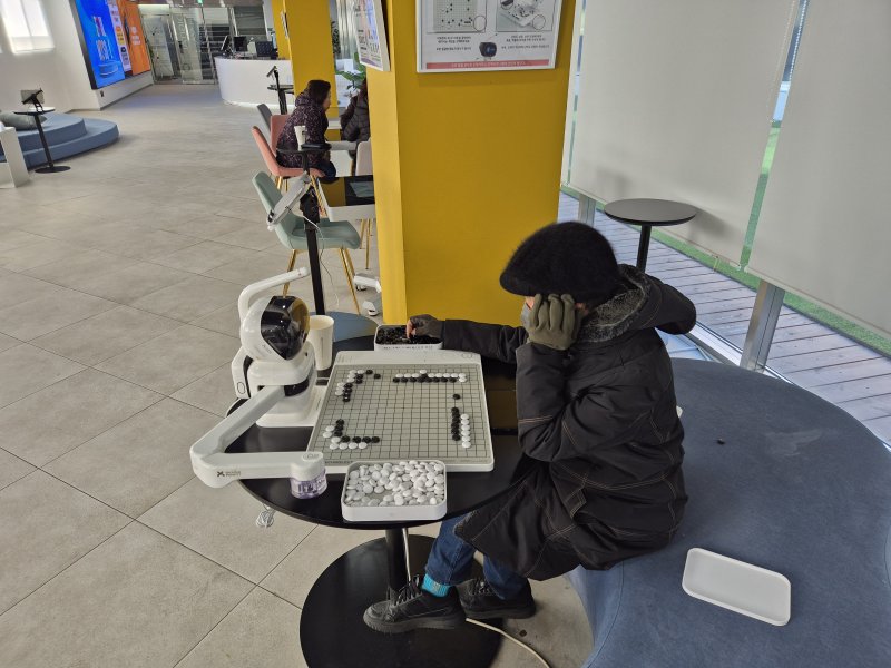 서울디지털동행플라자 내에 설치된 바둑로봇과 게임을 즐기고 있는 70대 방문객의 모습.