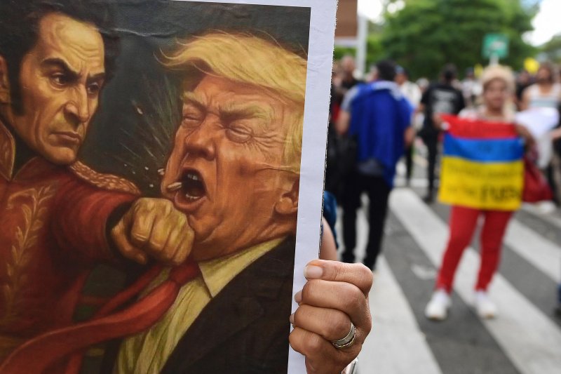 7일(현지시간) 콜롬비아 메데진에서 콜롬비아와 베네수엘라의 독립 영웅인 시몬 볼리바르가 도널드 트럼프 미국 대통령(오른쪽)을 가격하는 그림이 담긴 팻말을 든 시위대가 거리를 행진하고 있다.AFP연합뉴스