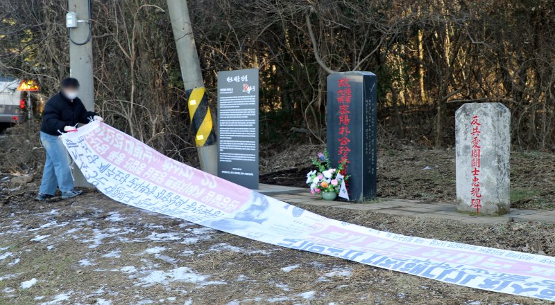 제주시 연동 주민센터 공무원이 9일 오후 제주시 연동 4·3 역사 왜곡 대응 안내판 '바로 세운 진실' 앞에 설치된 4·3 역사 왜곡 현수막을 강제 철거하고 있다. ⓒ News1 오미란 기자