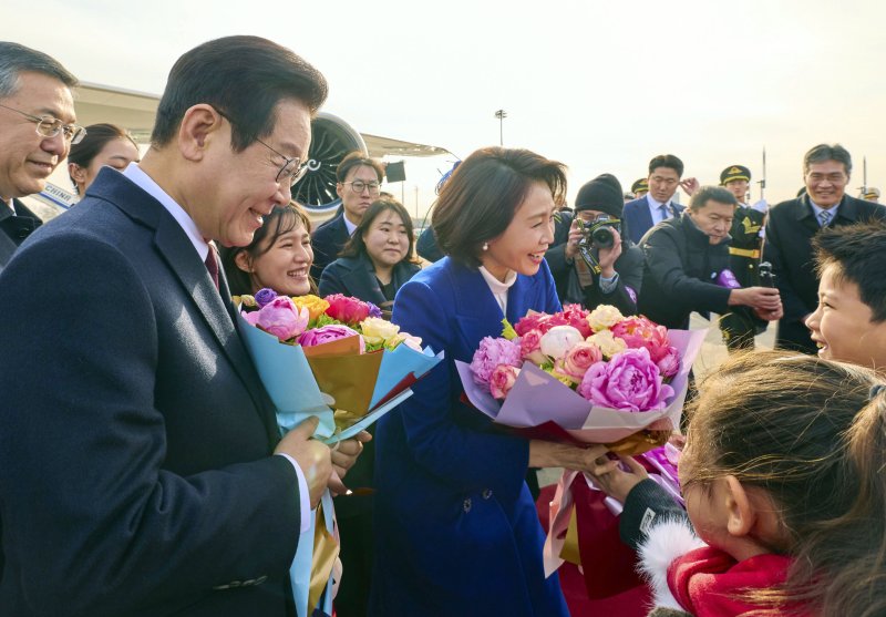 [베이징=뉴시스] 최동준 기자 = 중국을 국빈 방문한 이재명 대통령과 김혜경 여사가 4일(현지 시간) 베이징 서우두 국제공항에 도착해 화동들에게 꽃다발을 받고 있다. (공동취재) 2026.01.04. photocdj@newsis.com