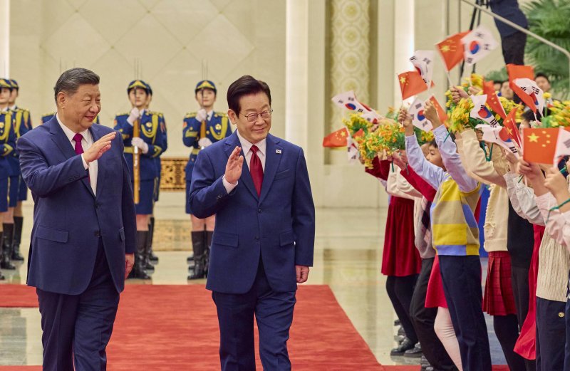 [베이징=뉴시스] 최동준 기자 = 중국을 국빈 방문 중인 이재명 대통령이 5일(현지 시간) 베이징 인민대회당에서 열린 공식환영식에서 시진핑 국가주석과 이동하며 환영 나온 어린이들에게 인사하고 있다. (공동취재) 2026.01.05. photocdj@newsis.com