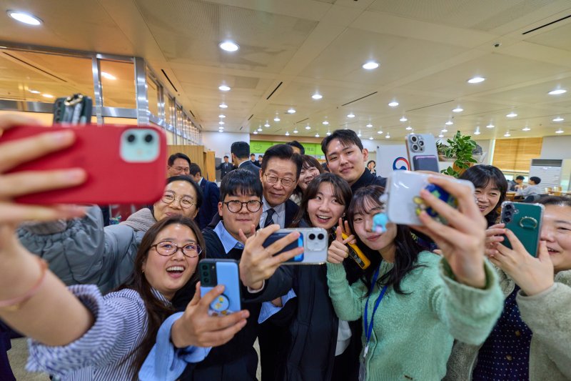 이재명 대통령이 정부 업무보고를 마친 뒤 서울 종로구 정부서울청사 별관 구내식당을 찾아 직원들과 기념촬영을 하고 있다. (대통령실 제공. 재판매 및 DB 금지) 2025.12.19/뉴스1 ⓒ News1 허경 기자