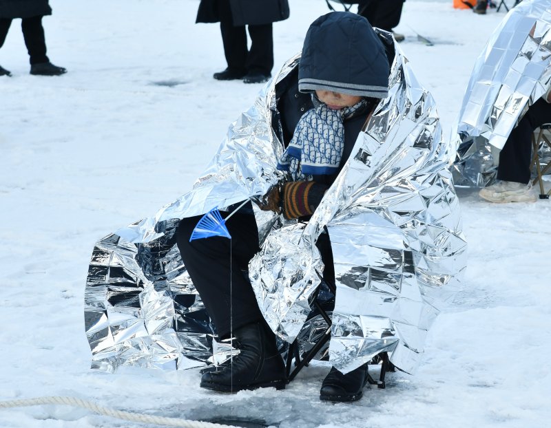 [화천=뉴시스]서백 기자=주말을 맞은 11일 화천산천어축제장을 찾은 아이가 산천어 얼음낚시를 위해 겨울 추위도 참으며 산천어를 기다리고 있다. (사진=화천군 제공) 2026.01.11. photo@newsis.com