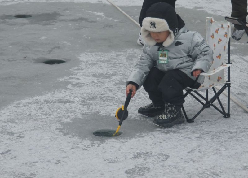[화천=뉴시스]서백 기자=주말을 맞은 11일 화천산천어축제장을 찾은 한 아이가 산천어를 잡아 기뻐하고 있다. 2026.1.11. syi23@newsis.com