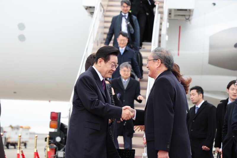 한일 정상회담을 위해 일본을 방문한 이재명 대통령이 13일 오사카 간사이 국제공항에 도착해 환영 인사들과 인사하고 있다. 뉴시스